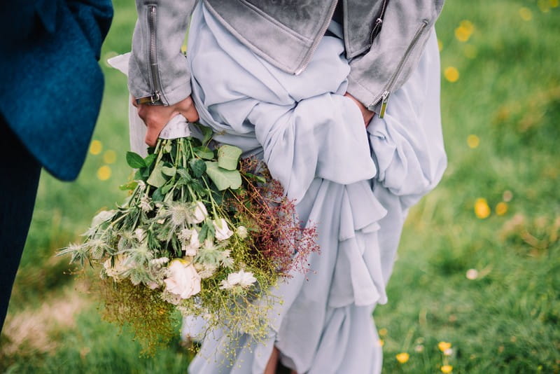 Bride's wild bouquet and bottom of her grey dress