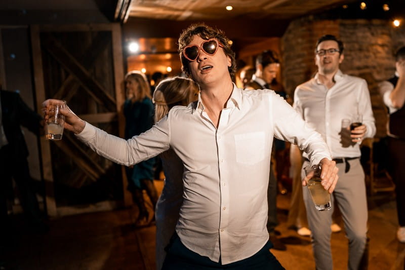 Wedding guest dancing with heart sunglasses on