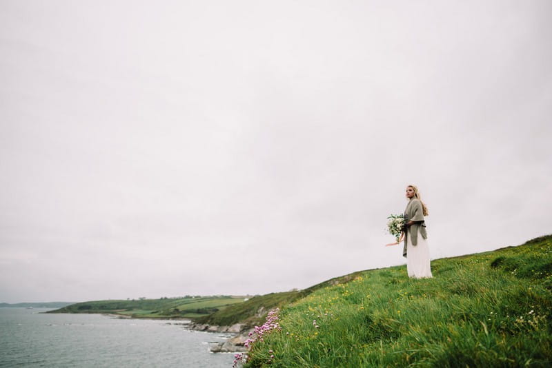 Bride standing looking out at coastline