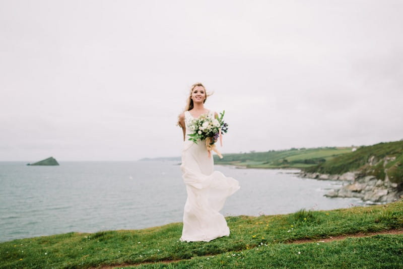 Bride standing by Devon coastline