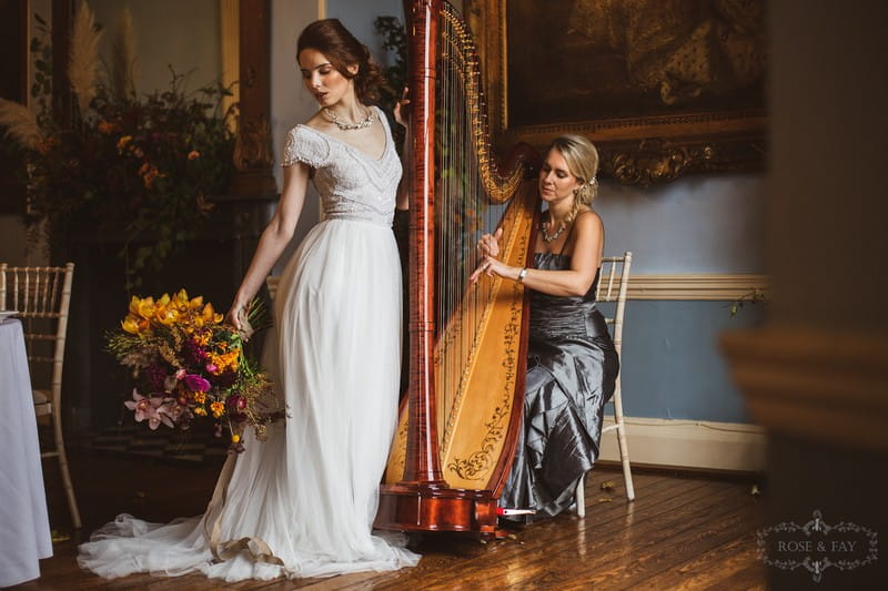 Elegant bride standing next to wedding harpist