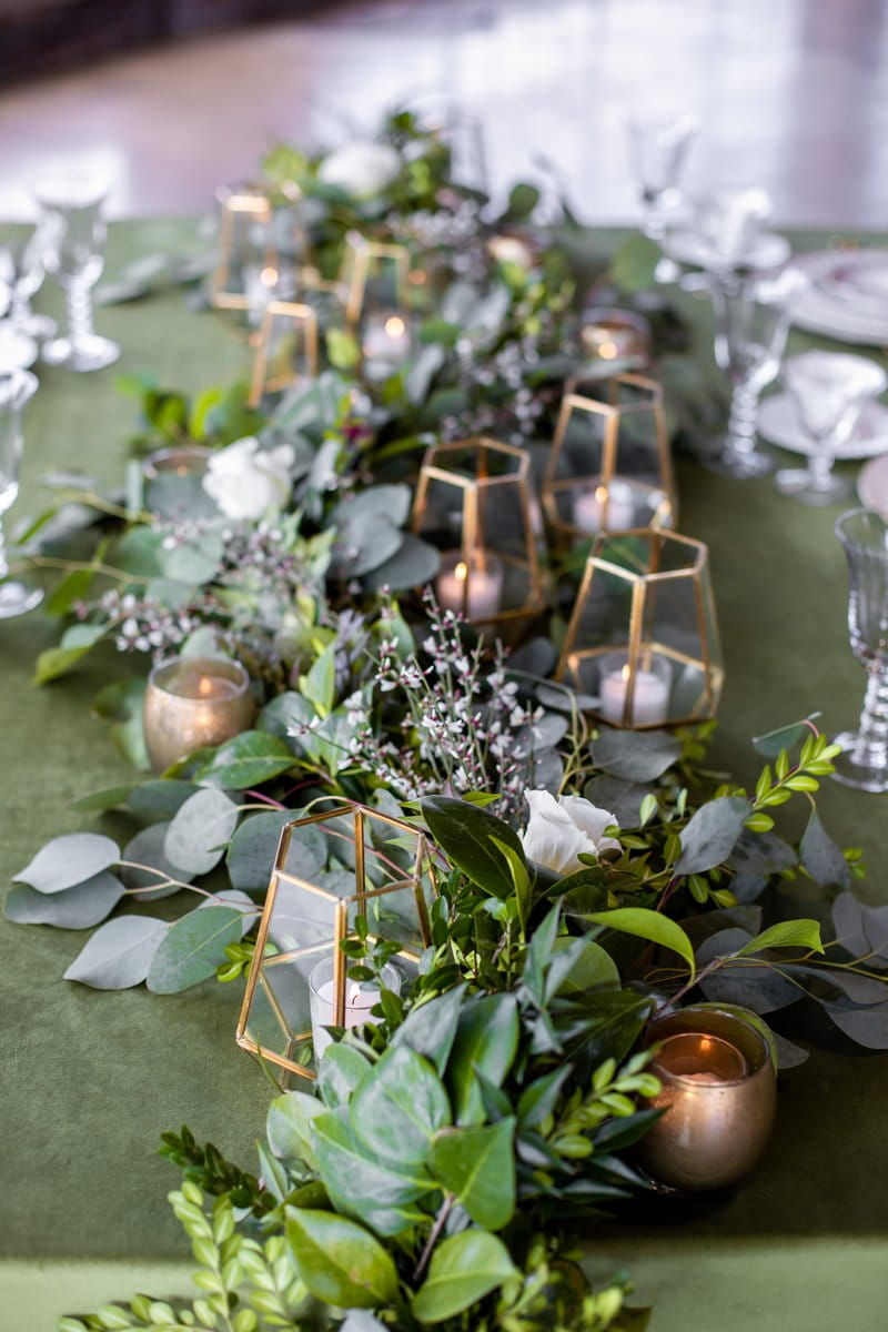Foliage wedding table runner with gold lanterns and votives