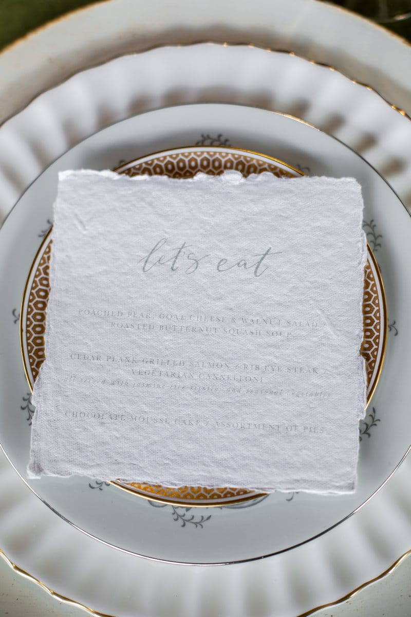 Wedding menu on top of plate with gold pattern
