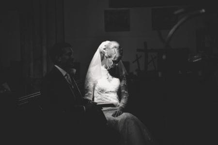 Black and white picture of bride sitting in light next to groom - Picture by Memories and Milestones Photography