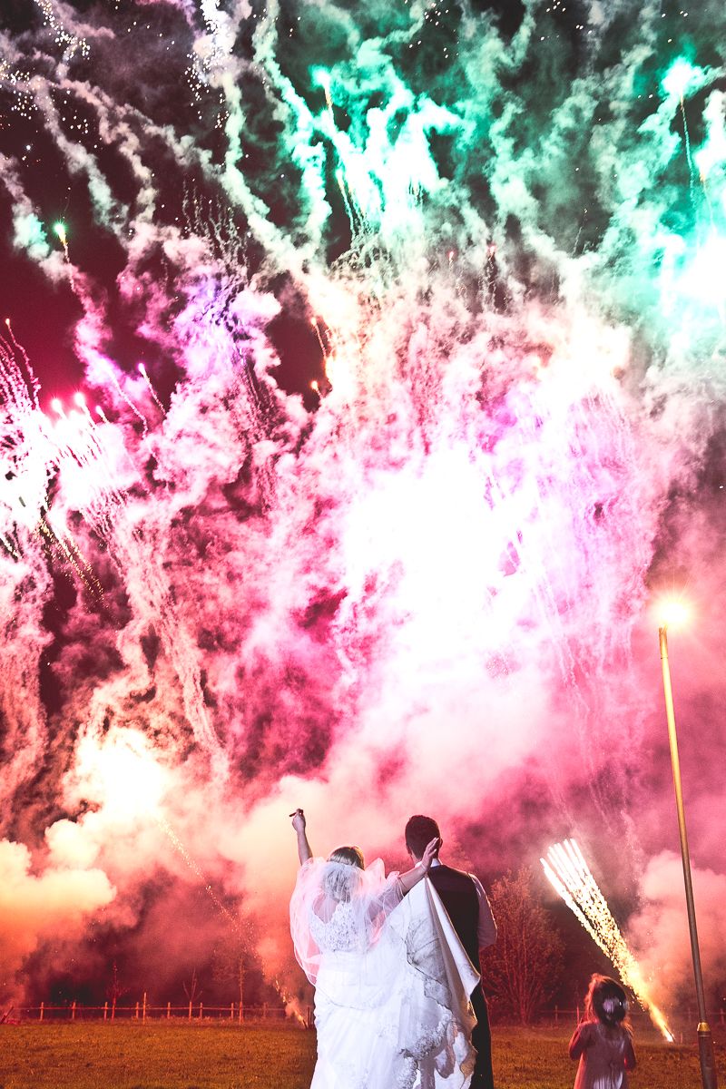 Bride and groom watching colourful fireworks display - Picture by Katie Sidell Photography