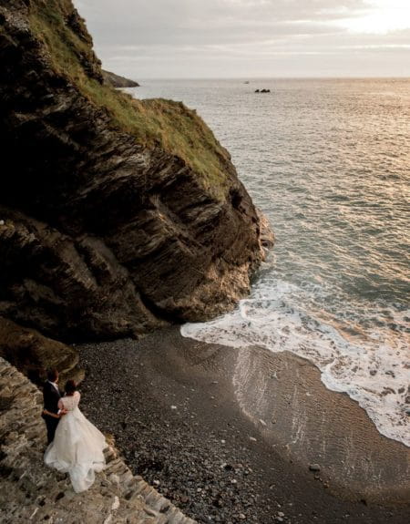 Bride and groom next to cliff near Tunnels Beaches looking out to sea - Picture by Robin Goodlad Photography