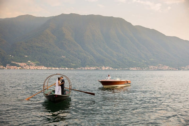 Bride and groom standing kissing on rowing boat - Picture by Damion Mower Photography