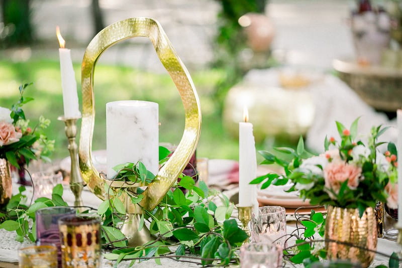 Foliage, candles and gold ornament on table