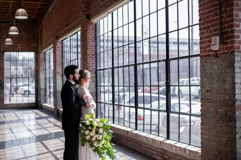 Bride and groom looking out of large windows at Events at Haven