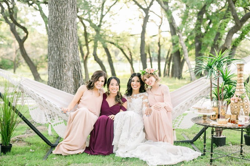 Bride-to-be and bridesmaids sitting in hammock