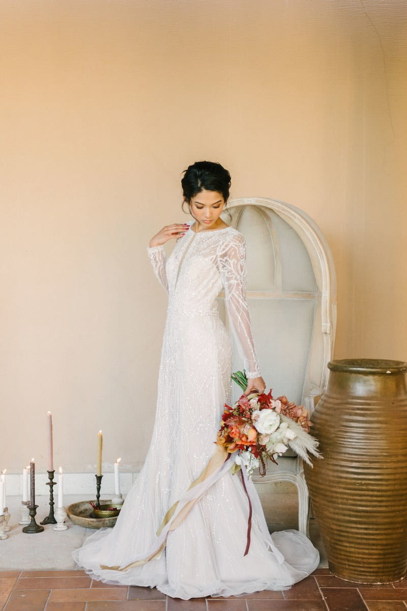 Bride holding bouquet in front of chair