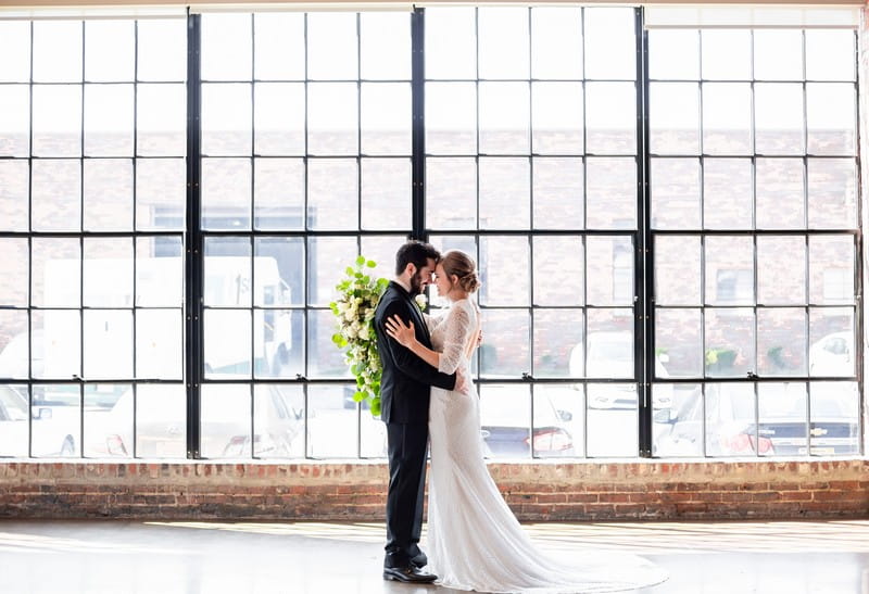 Bride and groom in front of large windows at Events at Haven