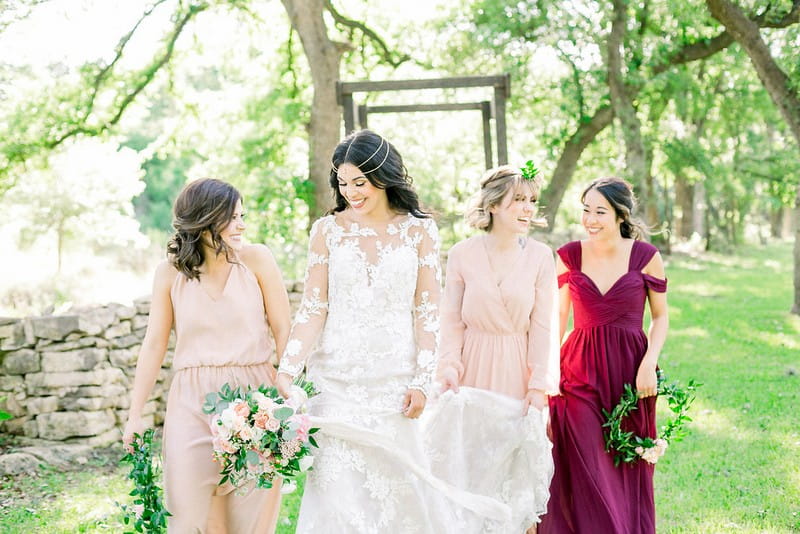 Bride-to-be walking with bridesmaids carrying foliage hoops