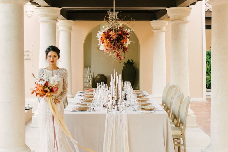 Bride standing by elegantly styled wedding table