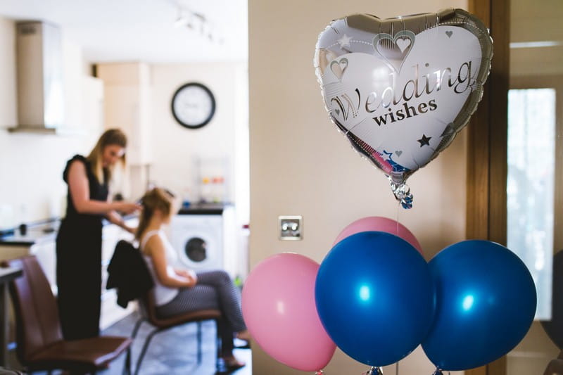Wedding balloons with bride having hair done in background