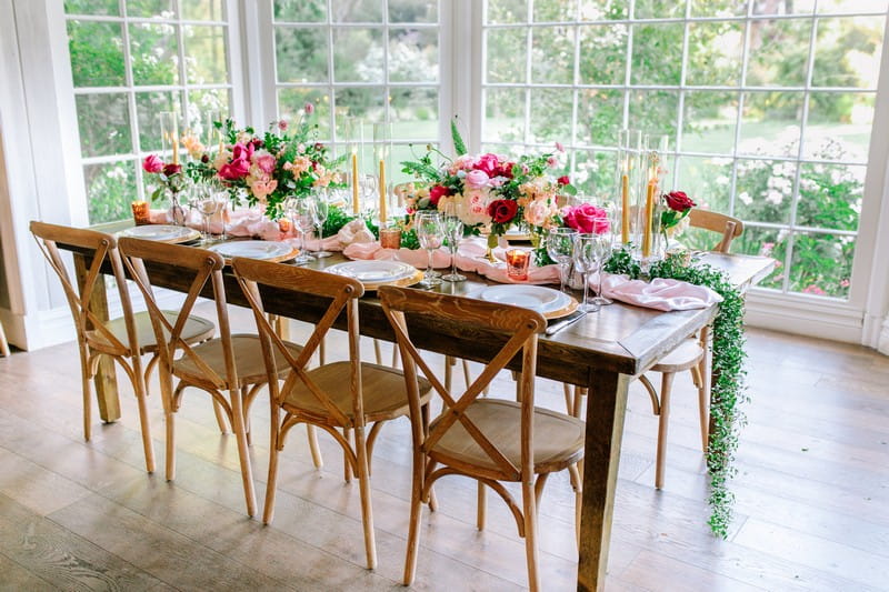Wedding table styled with burgundy and pink flowers