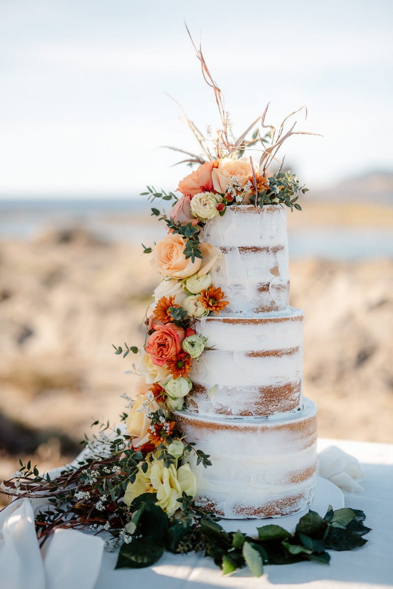 Naked wedding cake with cascading fresh flowers