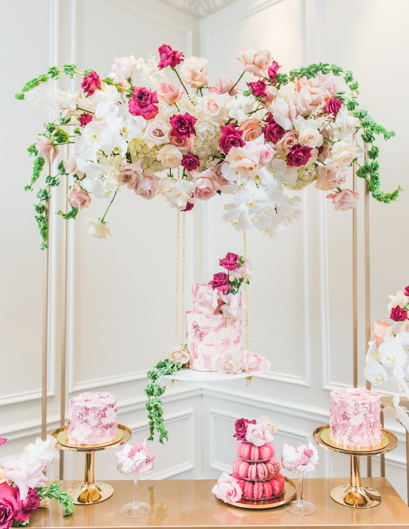 Desserts and cake on gold table with flowers overhead