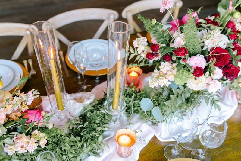 Tall candles in glass cylinders on wedding table