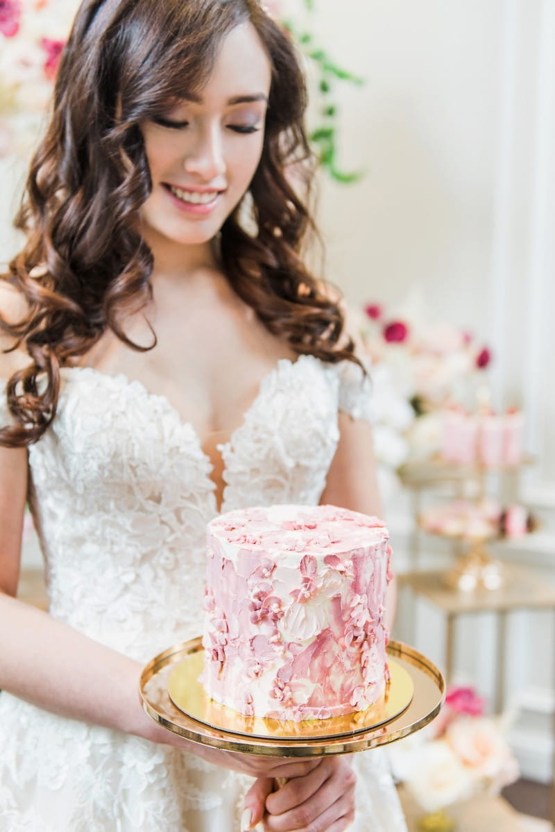 Bride holding pink wedding cake
