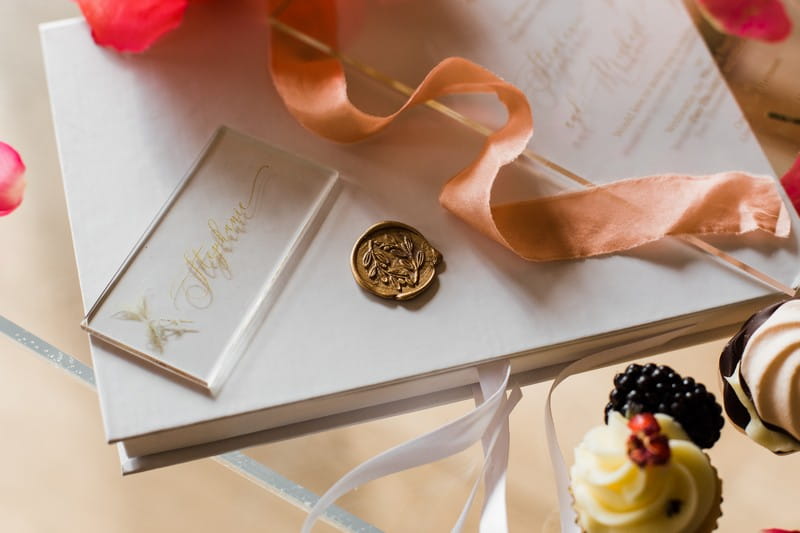 Gold wax seal with coral coloured ribbon