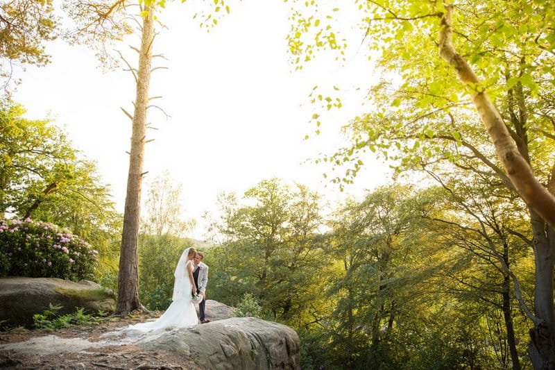 Bride and groom standing in woodland - Picture by Helen England Photography