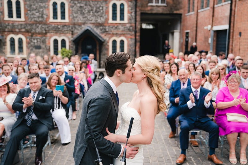 Bride and groom kissing at end of outdoor wedding ceremony - Picture by Married to my Camera