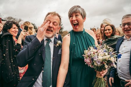 Excited bride with groom after walking through confetti shower - Picture by Tracey Warbey Photography