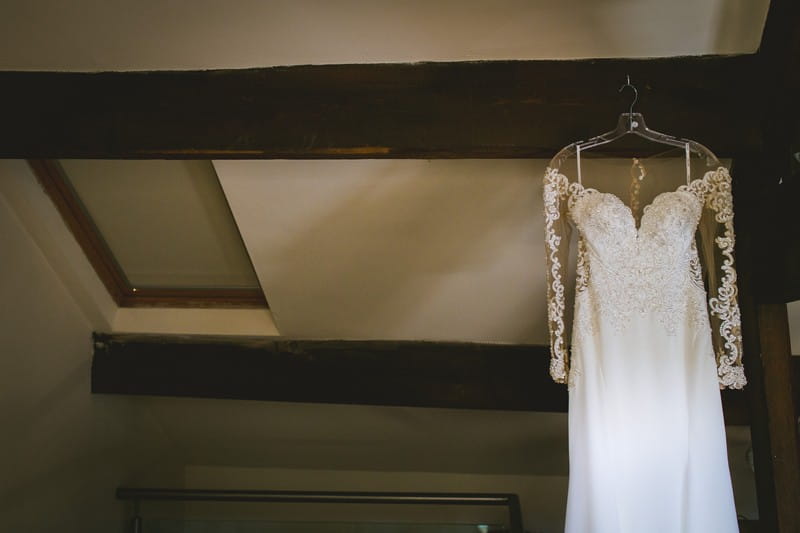 Wedding dress hanging from beam
