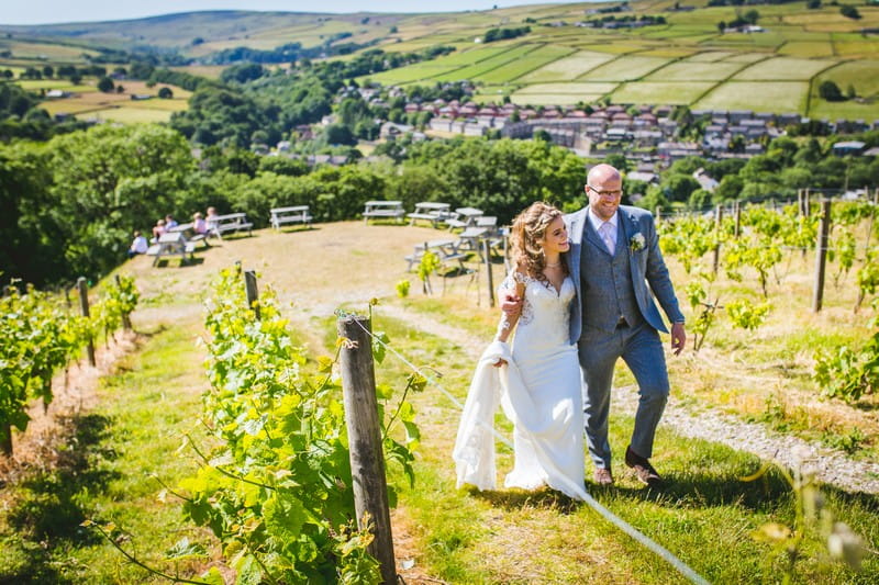 Bride and groom walking through Holmfirth Vineyard