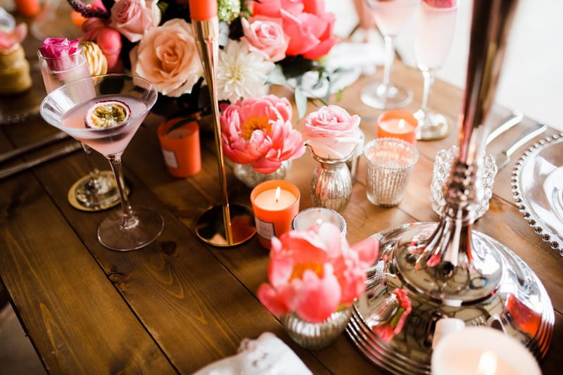 Living coral coloured table flowers and candles