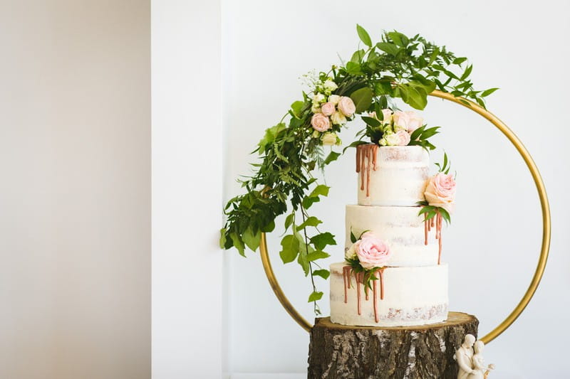 Semi naked wedding cake with flowers and drip icing