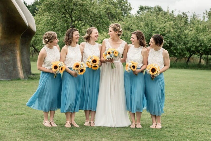 Bride with bridesmaids holding sunflower bouquets