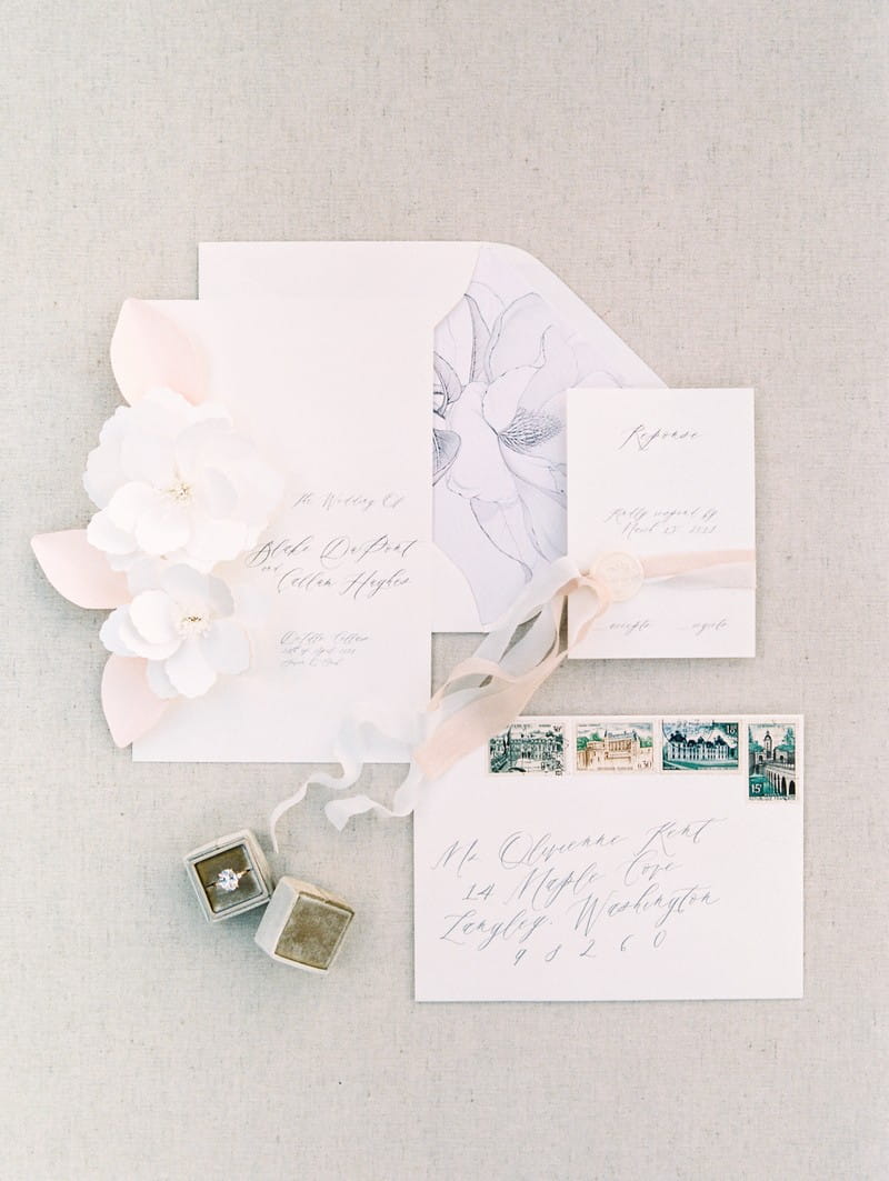 Elegant white wedding stationery with pink ribbon