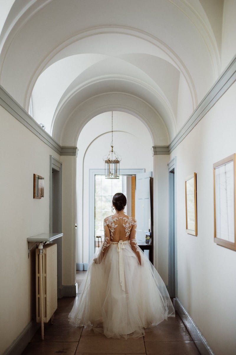 Bride walking through corridor at Fulham Palace