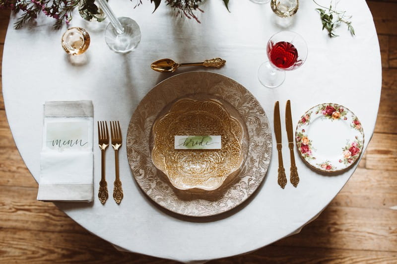 Wedding place setting with patterned plate and bowl, and gold cutlery