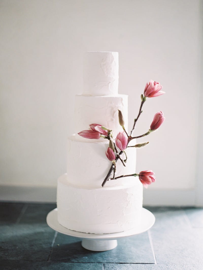 Wedding cake decorated with pink magnolia flowers