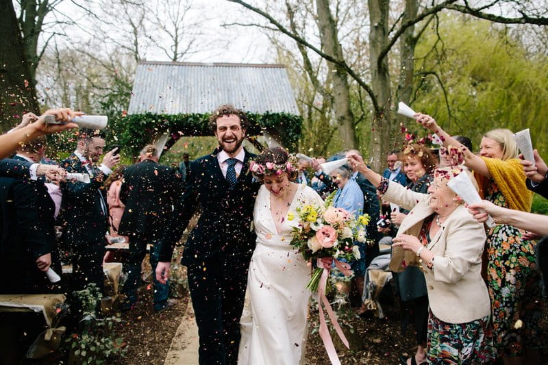 Bride and groom walking through shower of confetti - Picture by Dan Hough Photography