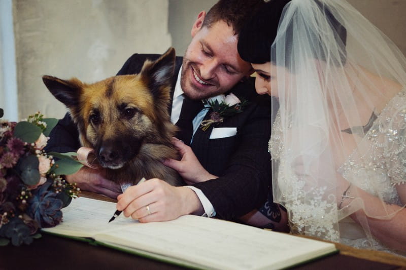 Groom signing register with dog there