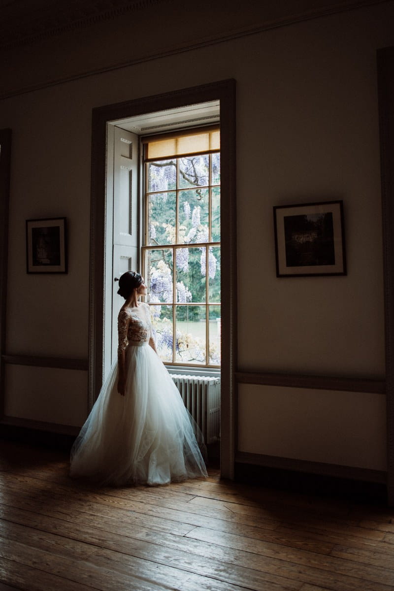 Bride standing looking out of the window at Fulham Palace