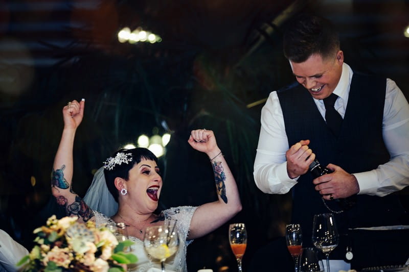 Bride with arms in the air during best man speech