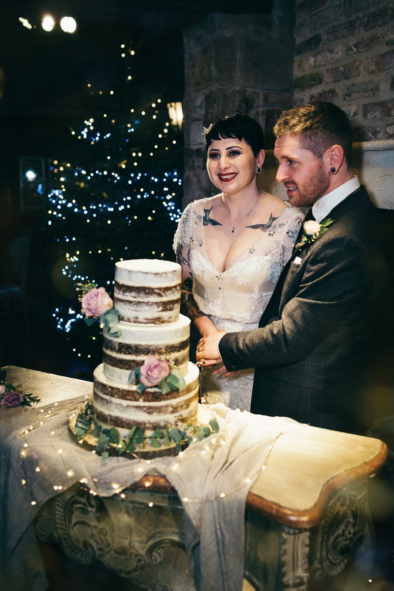 Bride and groom cutting naked wedding cake
