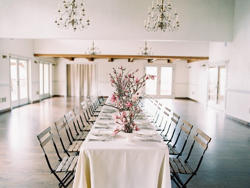 Long wedding table styled with pink magnolia flowers