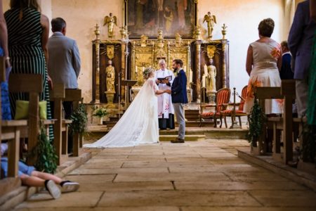 Young boy's legs poking out of seating onto aisle during wedding ceremony - Picture by Jonny Barratt Photography