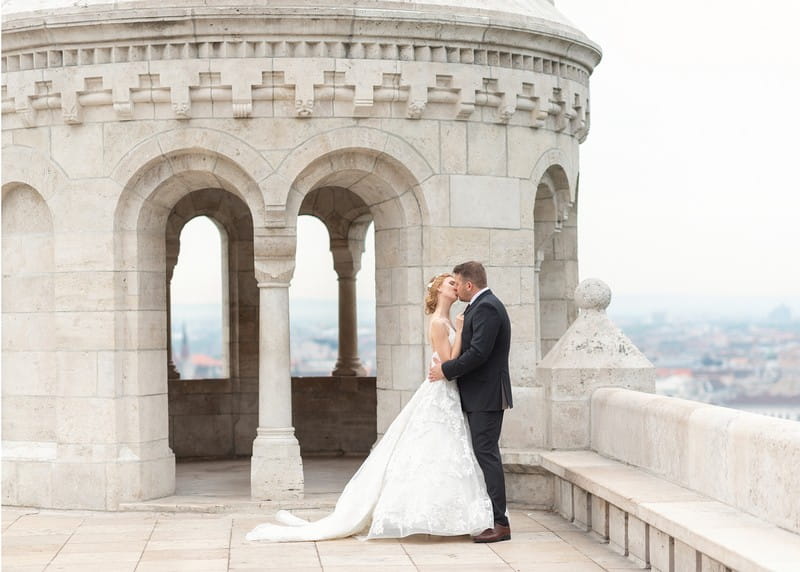 Bride and groom kissing at top of Fisherman’s Bastion in Budapest - Picture by Eva Tarnok Photography