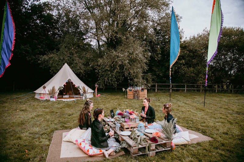Festival hen party outside with girls sitting at pallet seating area