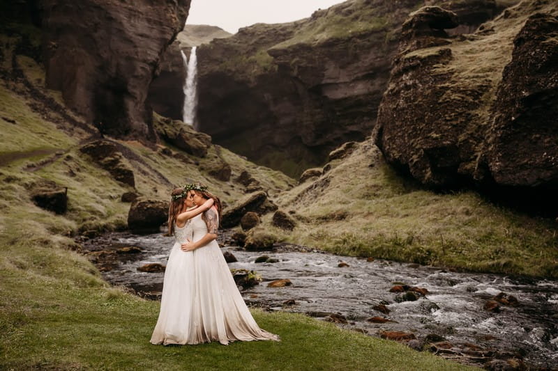 Brides kissing by stream in valley - Picture by Vee Taylor Photo