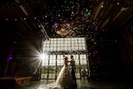 Bride and groom on dance floor as confetti falls around them - Picture by Hayley Baxter Photography