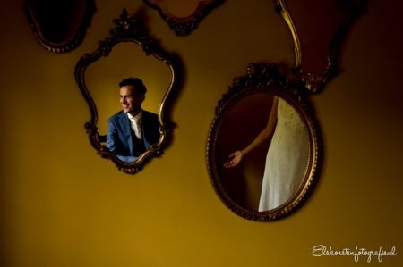 Mirrors on wall showing reflections of groom's head and bride's arm - Picture by Els Korsten Fotografie