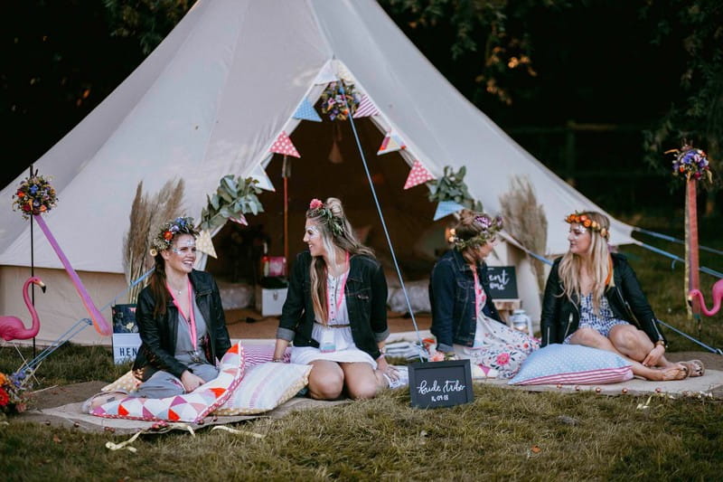 Girls sitting in front of tipi at festival hen party